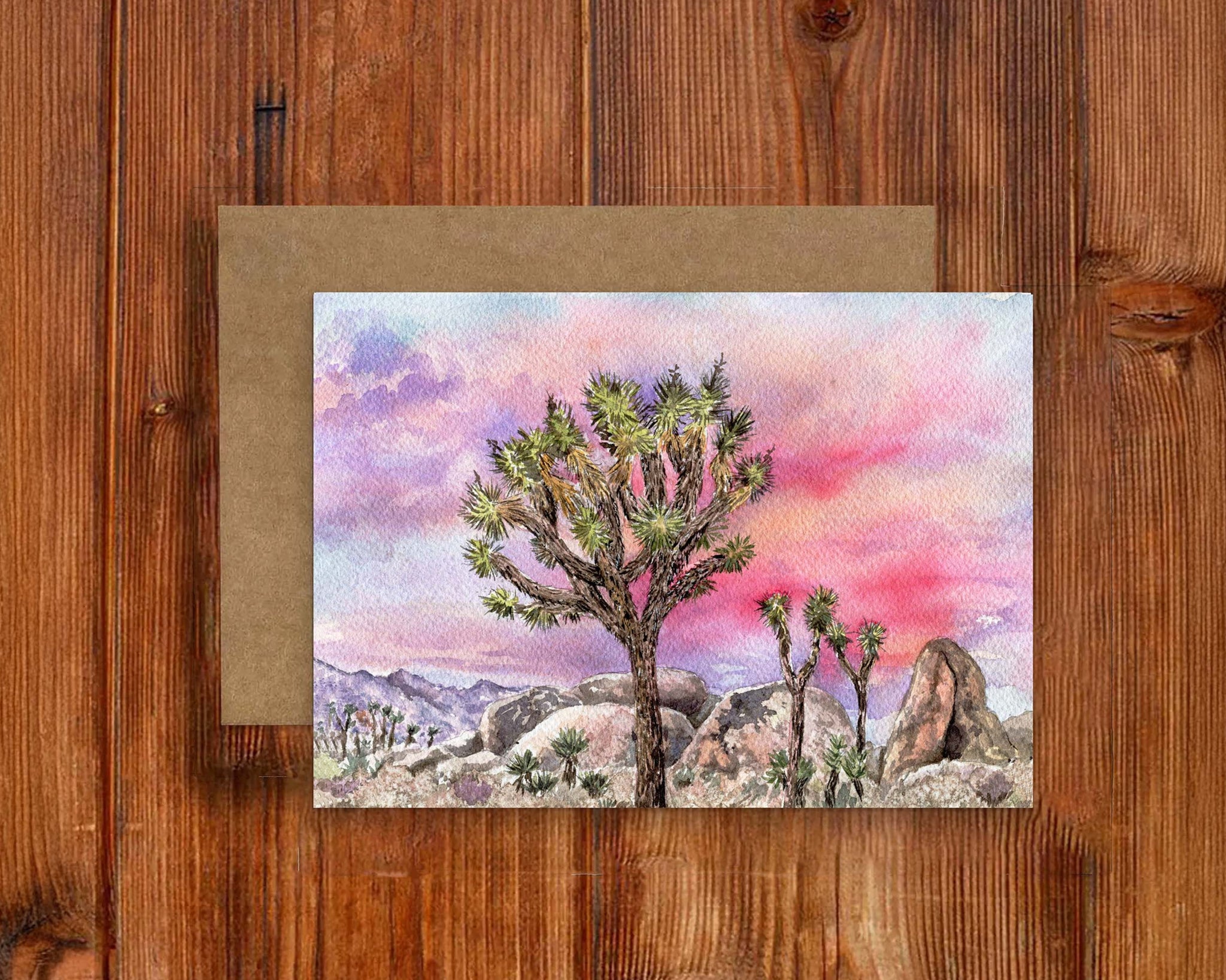 Card with a desert landscape featuring cacti on a wooden surface